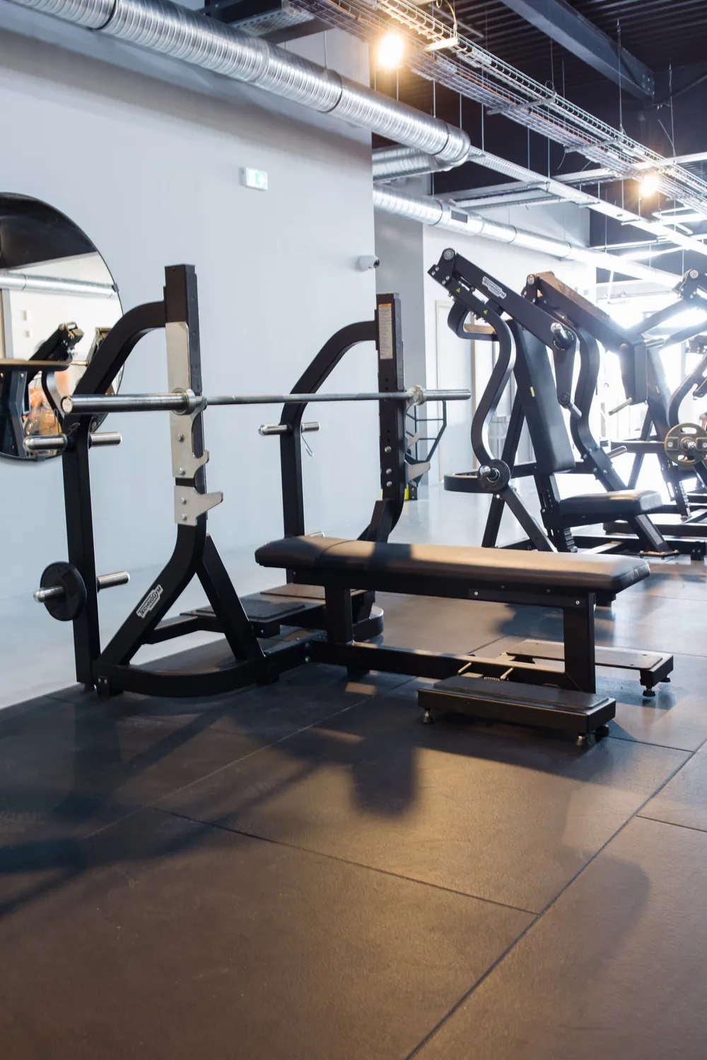 Banc et machines guidées sur le plateau de musculation